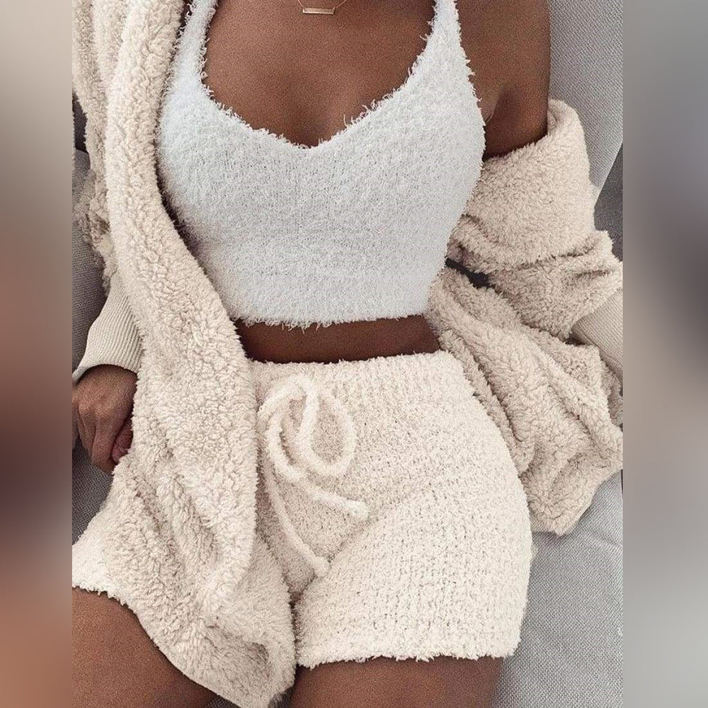 Kvinne iført mykt, koselig 3-delt sett i beige, bestående av shorts, topp og cardigan. Perfekt for komfort og stil hjemme.